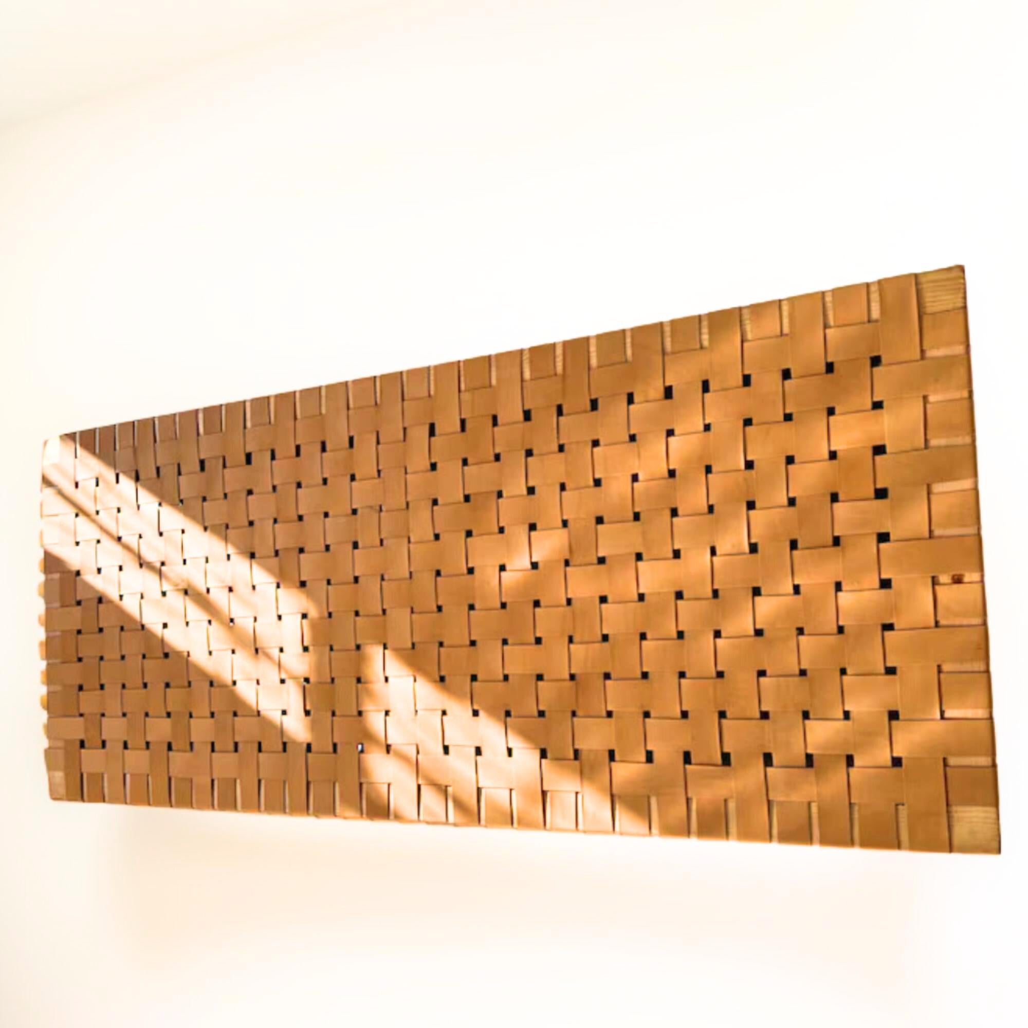 Side profile of a contemporary strap woven leather queen Hanging headboard highlighting its dynamic structure