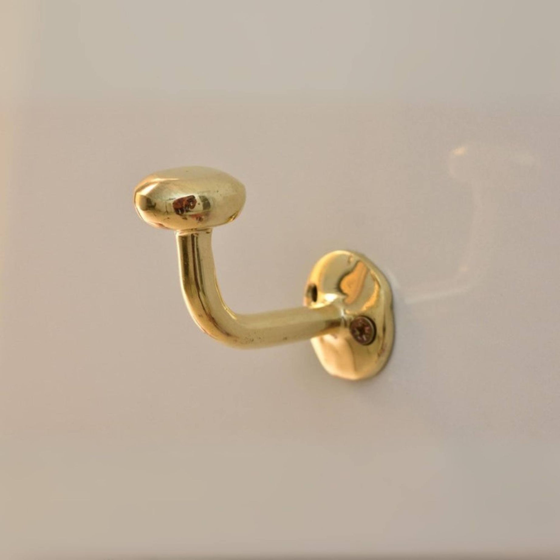 Gold brass Hook door handle on a white door