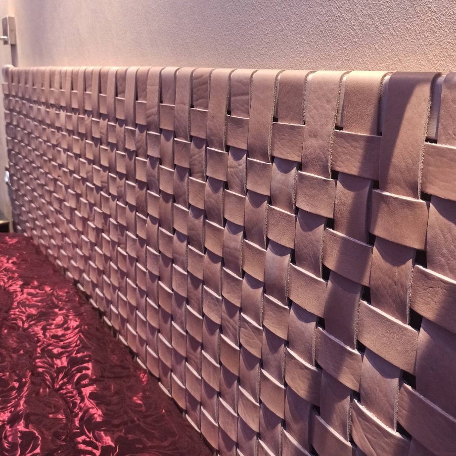 Artisanal woven strap leather headboard showcased in a modern bedroom setting, underlining its elegant and rustic appeal.