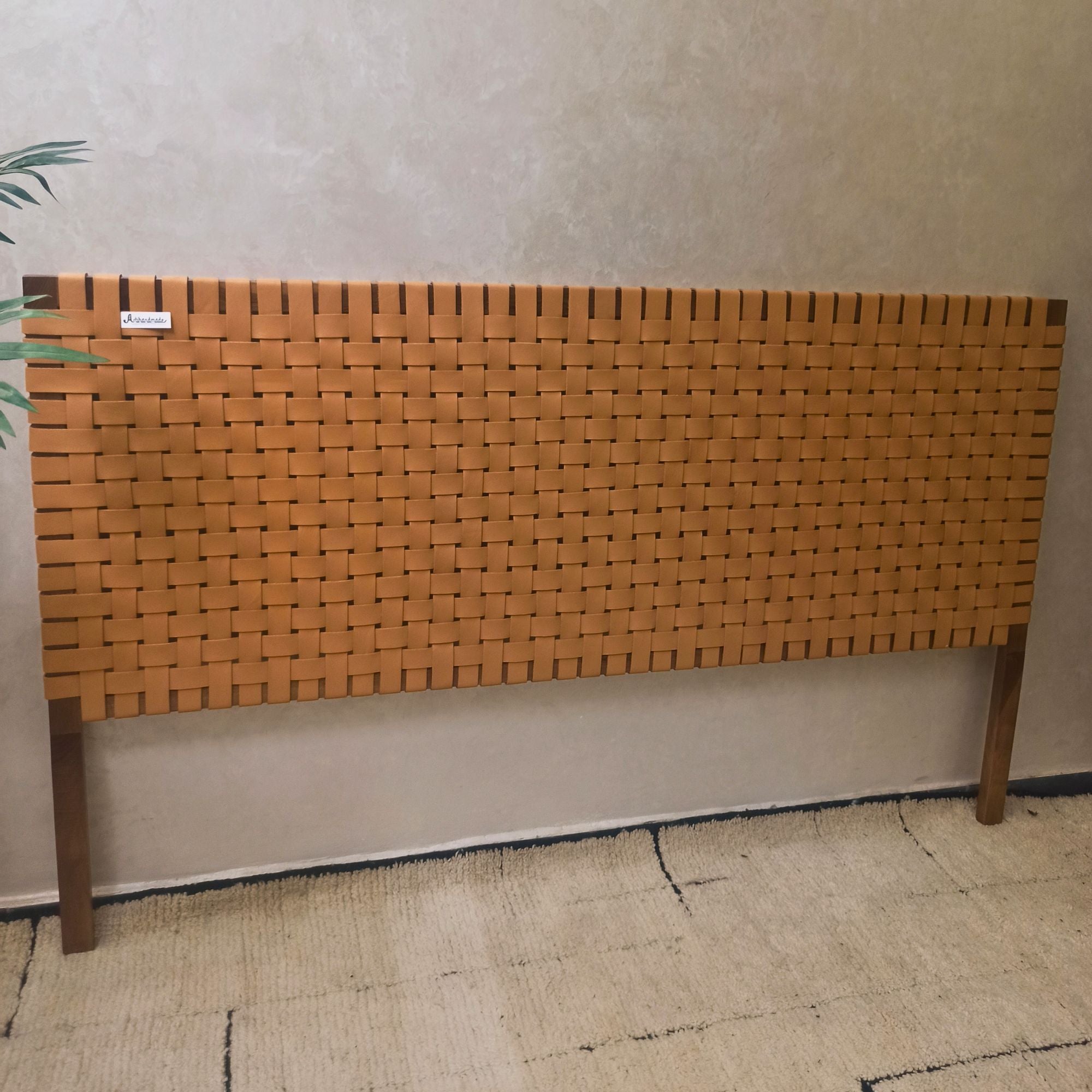 Woven wooden headboard against a plain wall