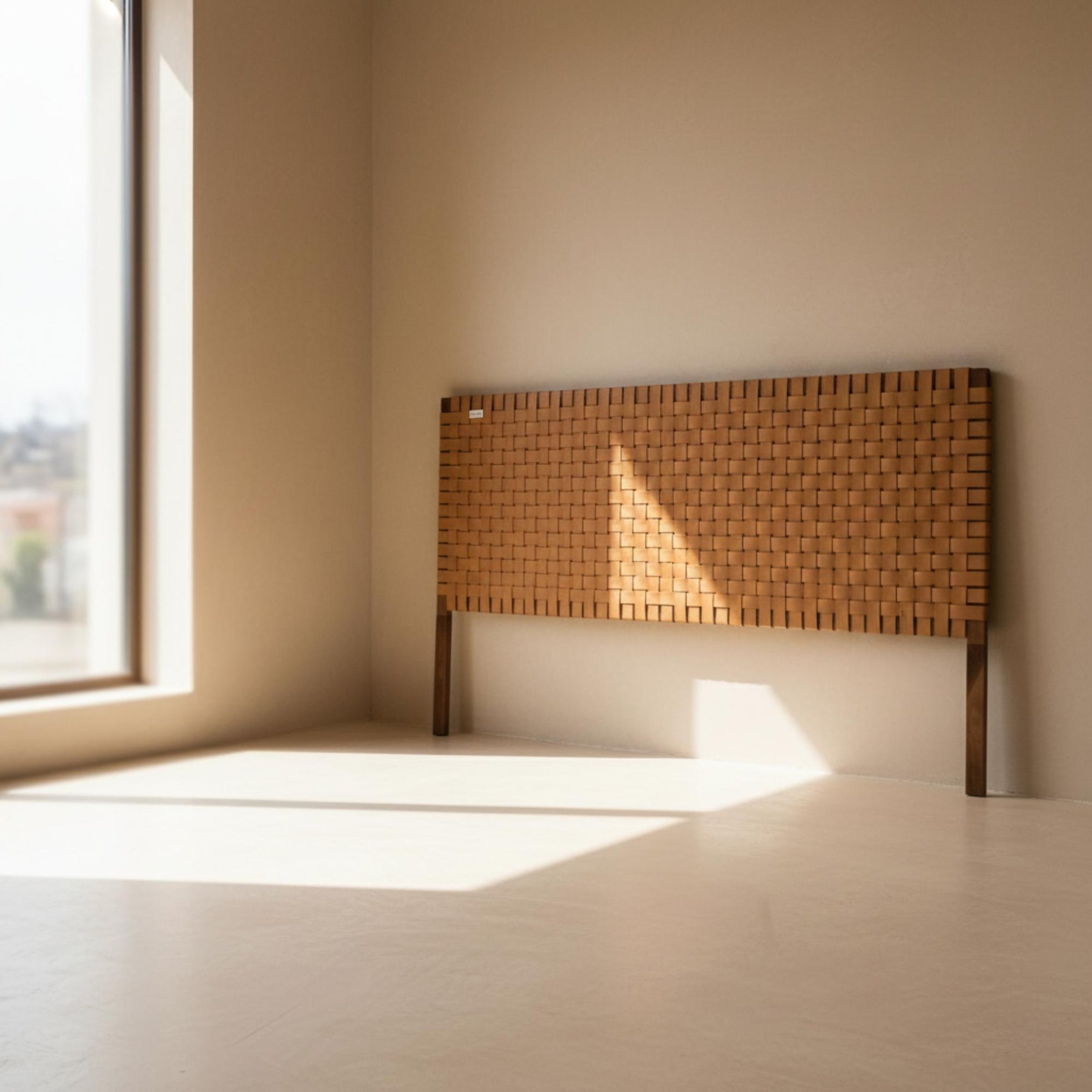 Woven wooden headboard against a beige wall with natural light